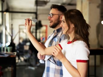 Dart für Anfänger – Mann und Frau spielen eine Runde Dart gegeneinander. Dart für Anfänger – Mann und Frau spielen eine Runde Dart gegeneinander.
