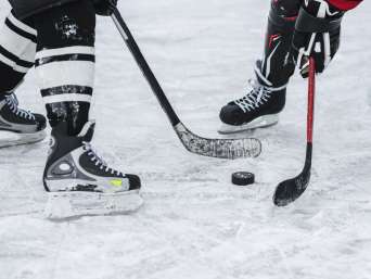 Eishockey für Anfänger: Momentaufnahme im Hockeyspiel, in der zwei Spieler um den Puck kämpfen. Eishockey für Anfänger: Momentaufnahme im Hockeyspiel, in der zwei Spieler um den Puck kämpfen.