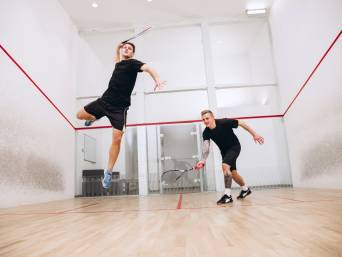 Squash Sport: Zwei Athleten spielen gemeinsam Squash auf einem Squashcourt. Squash Sport: Zwei Athleten spielen gemeinsam Squash auf einem Squashcourt.