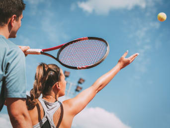 Tennis lernen – Frau übt den Aufschlag. Tennis lernen – Frau übt den Aufschlag.