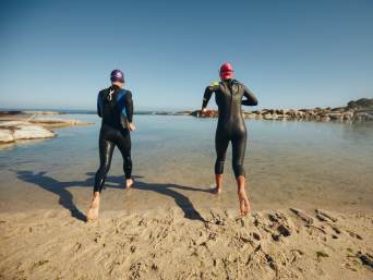 Triathlon für Anfänger: Athleten trainieren die Triathlon Disziplinen und laufen ins Wasser. Triathlon für Anfänger: Athleten trainieren die Triathlon Disziplinen und laufen ins Wasser.