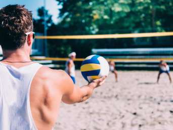 Volleybal voor beginners – speler doet een opslag tijdens beachvolleybal. Volleybal voor beginners – speler doet een opslag tijdens beachvolleybal.