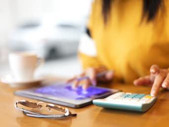 Studium finanzieren: Frau berechnet Studienkredit mit dem Taschenrechner. Studium finanzieren: Frau berechnet Studienkredit mit dem Taschenrechner.