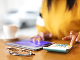 Frau berechnet Studienkredit mit dem Taschenrechner. Frau berechnet Studienkredit mit dem Taschenrechner.
