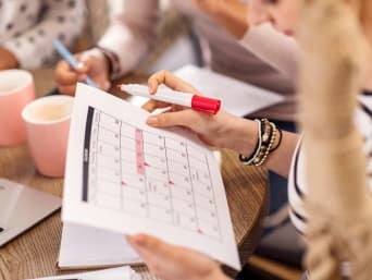 Zeitmanagement im Studium: Studentin plant Termine in einem Kalender. Zeitmanagement im Studium: Studentin plant Termine in einem Kalender.