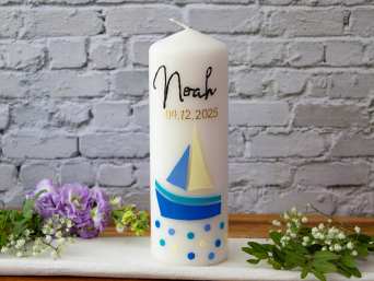 A christening candle with a picture of a sailboat. A christening candle with a picture of a sailboat.