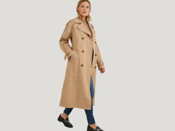 Trenchcoats als elegante Übergangsjacke: Frau in einem Trenchcoat. Trenchcoats als elegante Übergangsjacke: Frau in einem Trenchcoat.