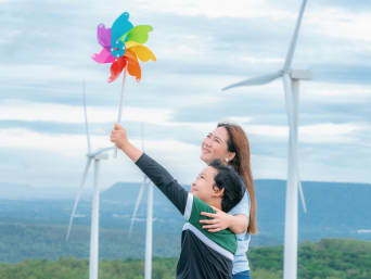 Wat is hernieuwbare energie? - Moeder en zoon onderzoeken windenergie met een windturbine. Wat is hernieuwbare energie? - Moeder en zoon onderzoeken windenergie met een windturbine.