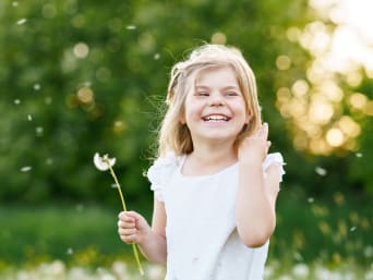 Milieubewustzijn: klein meisje heeft plezier met paardenbloem in de natuur.
