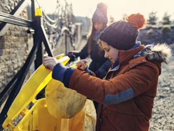 Afvalscheiding kinderen: jongen sorteert afval in de goede vuilnisbak. Afvalscheiding kinderen: jongen sorteert afval in de goede vuilnisbak.