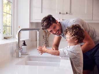 Water besparen voor kinderen: vader en zoon wassen hun handen. Water besparen voor kinderen: vader en zoon wassen hun handen.