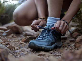 Meenemen naar Ardennen: Vrouw die de veters van haar wandelschoenen strikt. Meenemen naar Ardennen: Vrouw die de veters van haar wandelschoenen strikt.