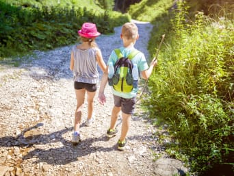 Ausflüge mit Kindern Niederösterreich: Mädchen und Bub wandern auf einem Schotterweg. Ausflüge mit Kindern Niederösterreich: Mädchen und Bub wandern auf einem Schotterweg.