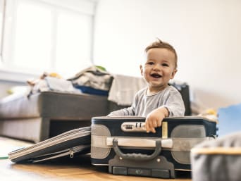 Babyvakantie – kind zit in een koffer. Babyvakantie – kind zit in een koffer.