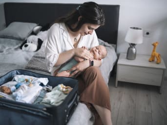 Erste Ferien mit Baby – Mutter packt die Koffer für die ersten Ferien mit Baby. Erste Ferien mit Baby – Mutter packt die Koffer für die ersten Ferien mit Baby.
