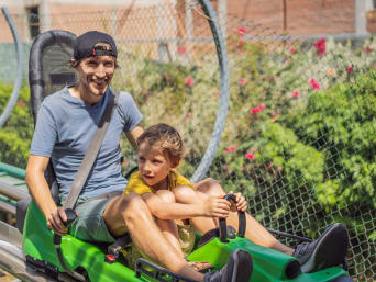 Familienurlaub Zillertal: Vater und Sohn fahren mit einer Sommerrodelbahn. Familienurlaub Zillertal: Vater und Sohn fahren mit einer Sommerrodelbahn.