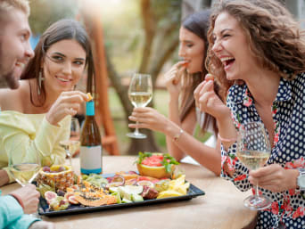 Verwenvakantie: Een groep vrienden die samen genieten van een glas wijn en een fruitschaal. Verwenvakantie: Een groep vrienden die samen genieten van een glas wijn en een fruitschaal.