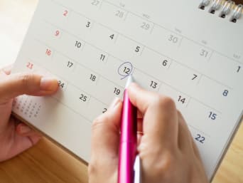 Verwenvakantie: een vrouw plant haar vakantie met een bureaukalender. Verwenvakantie: een vrouw plant haar vakantie met een bureaukalender.