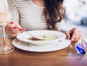 Spezialitäten Schaffhausen: Eine Frau isst eine Suppe in einem Restaurant und trinkt ein Glas Weisswein dazu. Spezialitäten Schaffhausen: Eine Frau isst eine Suppe in einem Restaurant und trinkt ein Glas Weisswein dazu.