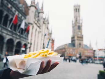 Activiteiten Vlaamse friet & bierbrouwerijen: bakje friet met Brugge op de achtergrond.