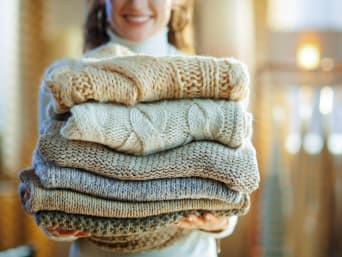 Washing wool: a young woman sorting her washing into piles. Washing wool: a young woman sorting her washing into piles.