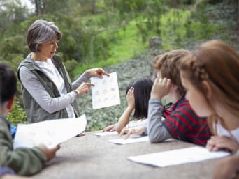 Lerares geeft in de natuur les aan een groep kinderen.  Lerares geeft in de natuur les aan een groep kinderen.