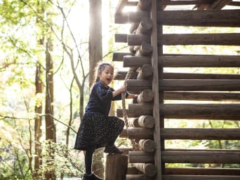 Activiteiten in het bos met kinderen – meisje speelt in een speeltuin. Activiteiten in het bos met kinderen – meisje speelt in een speeltuin.