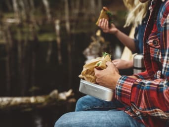 Hiking accessories: a group of hikers taking a break and eating lunch. Hiking accessories: a group of hikers taking a break and eating lunch.