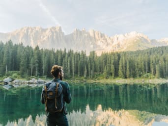 Hiking for beginners: a hiker taking a break in front of a mountain landscape. Hiking for beginners: a hiker taking a break in front of a mountain landscape.