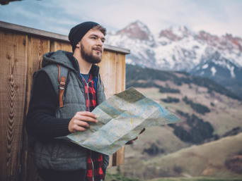 Wanderung planen: Wanderer macht Rast und wirft einen Blick auf eine Wanderkarte. Wanderung planen: Wanderer macht Rast und wirft einen Blick auf eine Wanderkarte.