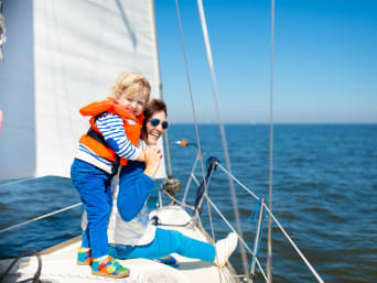 Uitrusting voor het zeilen – Moeder en zoon op een zeilboot met reddingsvest en zonnebril. Uitrusting voor het zeilen – Moeder en zoon op een zeilboot met reddingsvest en zonnebril.