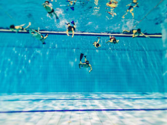 Unterwasserhockey Training: Einige Taucher mit Flossen trainieren in einem tiefen Schwimmbecken. Unterwasserhockey Training: Einige Taucher mit Flossen trainieren in einem tiefen Schwimmbecken.