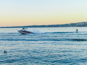 Wasserski: Ein Motorboot zieht einen Wasserskifahrer über einen See. Wasserski: Ein Motorboot zieht einen Wasserskifahrer über einen See.