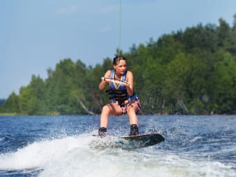 Wakeboard – Frau nutzt eine Wakeboard-Anlage auf einem See. Wakeboard – Frau nutzt eine Wakeboard-Anlage auf einem See.