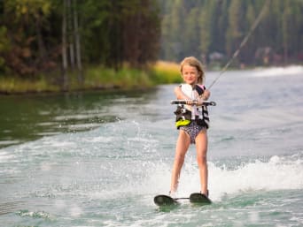 Wasserski Kinder: Junges Mädchen fährt auf einem See Wasserski. Wasserski Kinder: Junges Mädchen fährt auf einem See Wasserski.
