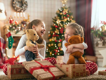 Christmas traditions: Two girls opening Christmas gifts. Christmas traditions: Two girls opening Christmas gifts.