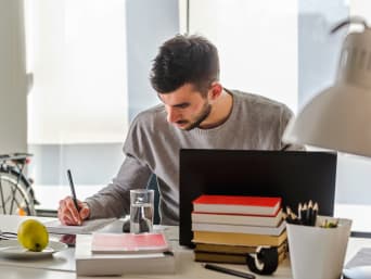 Professionele bijscholing: jonge man studeert thuis aan zijn bureau. Professionele bijscholing: jonge man studeert thuis aan zijn bureau.