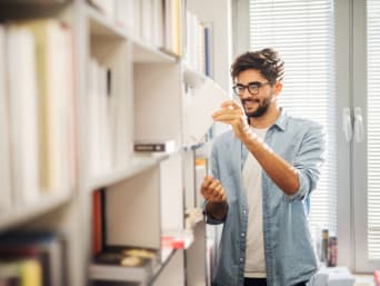 Mann sucht ein Buch in der Bibliothek zur persönlichen Weiterbildung. Mann sucht ein Buch in der Bibliothek zur persönlichen Weiterbildung.