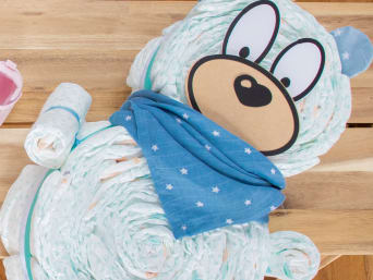 Unterschiedliche mit Babysachen verzierte Windelgeschenke geschlechtsneutral gestaltet. Unterschiedliche mit Babysachen verzierte Windelgeschenke geschlechtsneutral gestaltet.