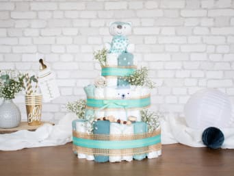 Windeltorte mit unterschiedlichen Babysachen bestückt und in neutralen Farben dekoriert. Windeltorte mit unterschiedlichen Babysachen bestückt und in neutralen Farben dekoriert.