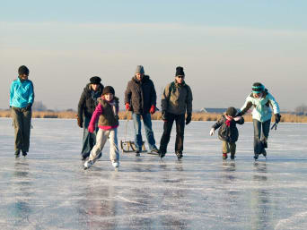 Eislaufen auf dem See: Familie läuft gemeinsam Schlittschuh auf einem zugefrorenen See. Eislaufen auf dem See: Familie läuft gemeinsam Schlittschuh auf einem zugefrorenen See.