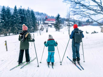 Langlauf Schweiz: Familie auf Skiern betrachtet die verschneite Landschaft. Langlauf Schweiz: Familie auf Skiern betrachtet die verschneite Landschaft.