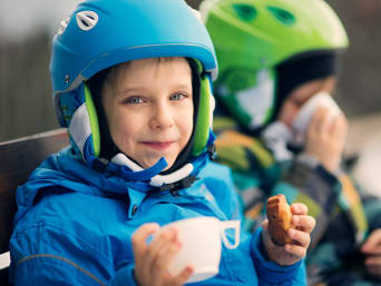 Langlauf mit Kindern: Kinder genießen eine kleine Pause beim Skifahren. Langlauf mit Kindern: Kinder genießen eine kleine Pause beim Skifahren.