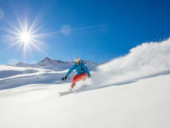 Wintersport: Wintersportler fährt auf einem Snowboard den Hang herunter. Wintersport: Wintersportler fährt auf einem Snowboard den Hang herunter.