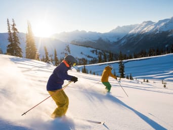 Schneeurlaub Österreich: Skifahrer fahren schneebedeckten Hang herunter. Schneeurlaub Österreich: Skifahrer fahren schneebedeckten Hang herunter.