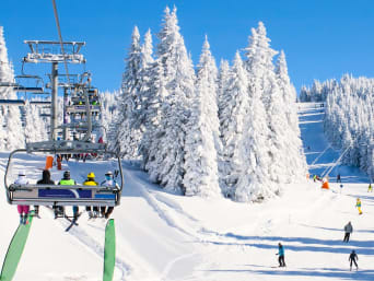 Skifahren Regeln: Familie fahren mit einem Sessellift den Berg hinauf. Skifahren Regeln: Familie fahren mit einem Sessellift den Berg hinauf.
