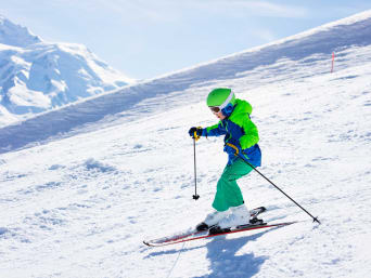 Kinder Skifahren: Junge auf Skiern fährt einen schneebedeckten Hang herunter. Kinder Skifahren: Junge auf Skiern fährt einen schneebedeckten Hang herunter.