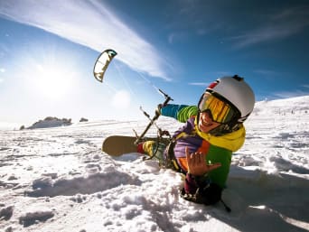 Trendsportart Snowkite: Snowboarder lässt sich von einem Zugdrachen ziehen. Trendsportart Snowkite: Snowboarder lässt sich von einem Zugdrachen ziehen.