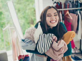 A woman sorting out her old clothes from her wardrobe. A woman sorting out her old clothes from her wardrobe.