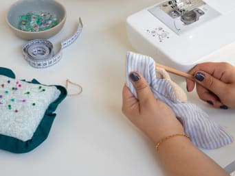 Making reusable kitchen roll: turning the piece of fabric over and stretching out the corners. Making reusable kitchen roll: turning the piece of fabric over and stretching out the corners.